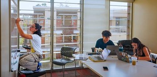 three students use a study room in a residence hall